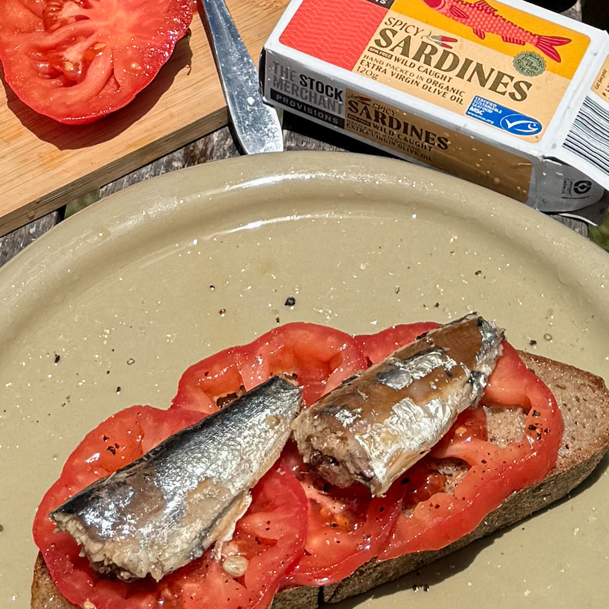 Sardine fillets served on tomato toast with the Spicy Sardines tin alongside