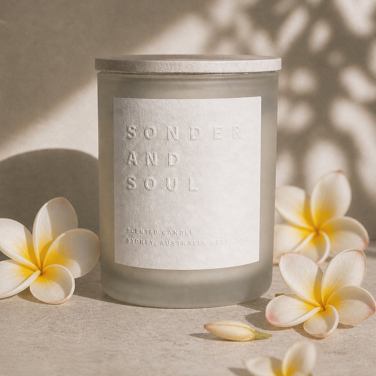 Wild Frangipani soy candle by Sonder and Soul, styled with the fragrance notes