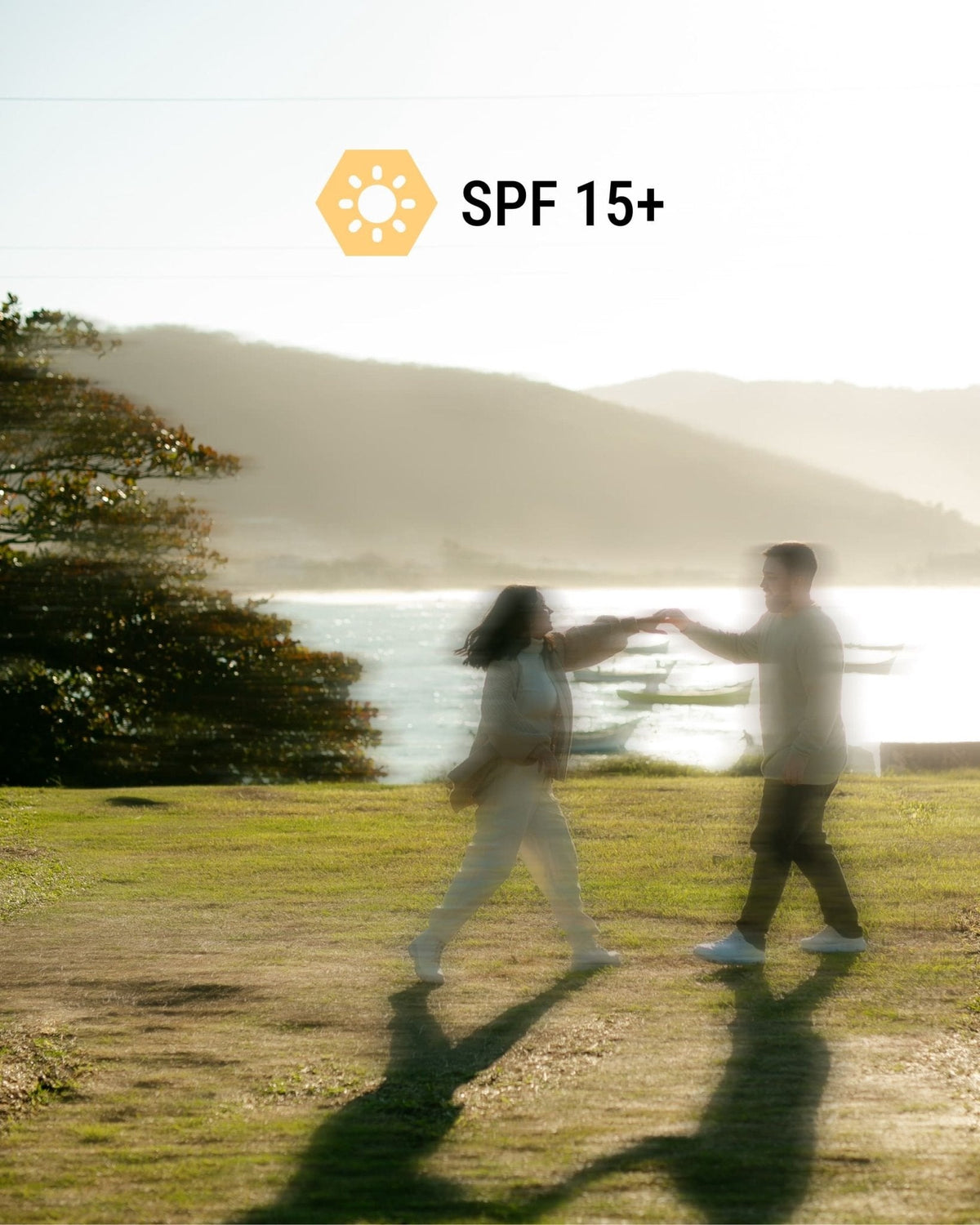 Two people walking a New Zealand coastline, marked SPF 15+